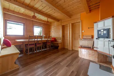 a kitchen and dining room with a table and chairs at Koča Zlatorog - Velika planina in Stahovica