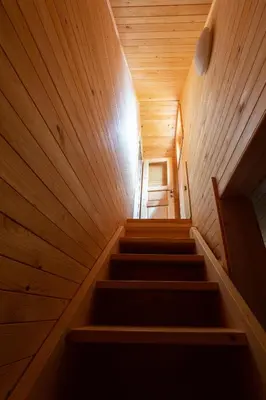 a staircase in a wooden house with a stair case at Koča Zlatorog - Velika planina in Stahovica