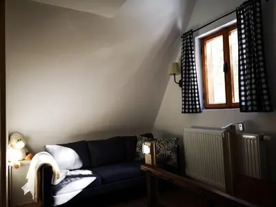 a living room with a blue couch and a window at Cozy Private Cabin in the heart of Triglav National Park in Trenta
