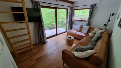 a living room with a couch and a tv at Cozy Private Cabin in the heart of Triglav National Park in Trenta
