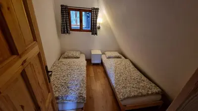 an attic room with two beds and a window at Cozy Private Cabin in the heart of Triglav National Park in Trenta