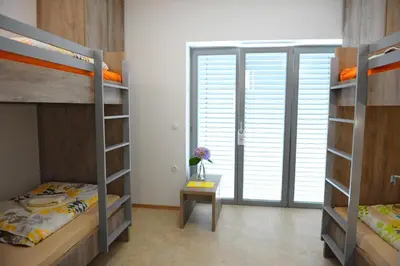 a room with two bunk beds and a table at Hostel Ormož in Ormoz