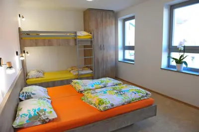 a bedroom with two bunk beds and an orange mattress at Hostel Ormož in Ormoz