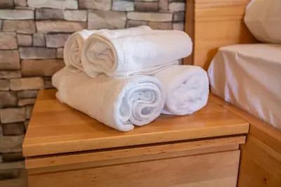 a pile of towels sitting on a wooden table at Camping Danica Cottage Stan in Bohinj