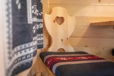 a wooden cabin with a bench with a heart on it at Camping Danica Cottage Stan in Bohinj