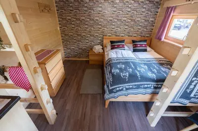 a bedroom in a tiny house with a bed at Camping Danica Cottage Stan in Bohinj