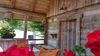 a wooden cabin with a table and a window at Camping Danica Cottage Stan in Bohinj