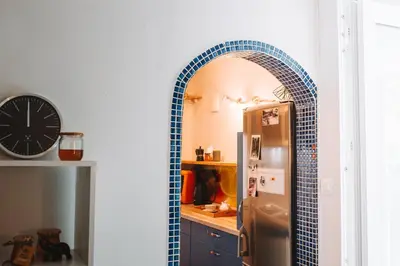 a kitchen with a blue tile archway next to a refrigerator at Apartment with Atrium Anabela in Tolmin