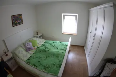 a bedroom with a bed with a green blanket at Rock&Lodge in Bohinj