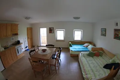 a living room with a couch and a bed and a table at Rock&Lodge in Bohinj