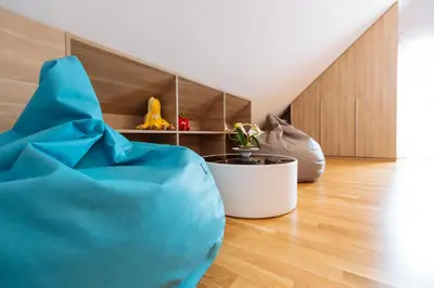 a living room with a blue couch on the floor at Maline Apartments in Bled
