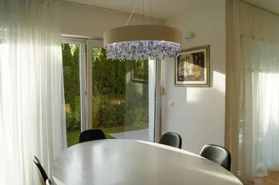 a dining room table with chairs and a chandelier at Maline Apartments in Bled