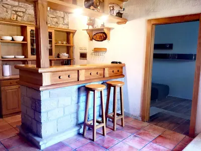 a kitchen with a counter with stools at it at Apartment Trieste HerMes arT in Sežana