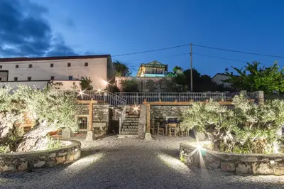 a courtyard with trees in front of a building at Apartment Trieste HerMes arT in Sežana
