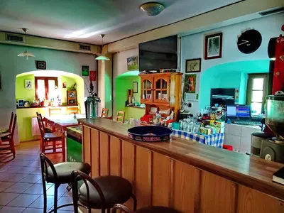 a bar in a restaurant with a counter and chairs at Dom Pristava in Jesenice