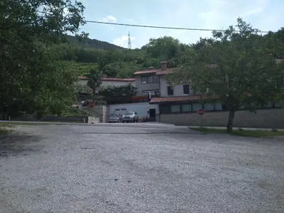 a gravel parking lot in front of a house at Gostišče Oddih in Solkan