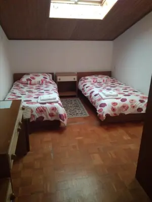 a bedroom with two beds and a table in it at Gostišče Oddih in Solkan