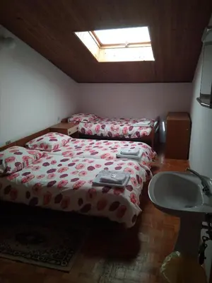 a bedroom with a bed and a sink and a window at Gostišče Oddih in Solkan