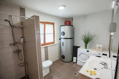 a bathroom with a toilet a sink and a washer at House of Adventure - The Base to explore Slovenia in Laze v Tuhinju