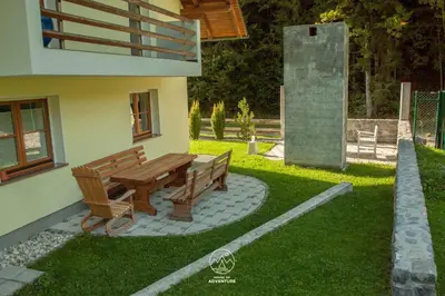 a wooden bench sitting outside of a house at House of Adventure - The Base to explore Slovenia in Laze v Tuhinju