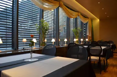 a conference room with tables and chairs and large windows at Hotel Jozef in Idrija