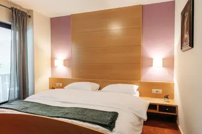 a bedroom with a large white bed with two pillows at Vila Podvin in Radovljica