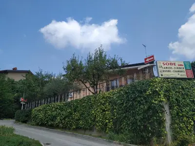 a store sign on a hedge in front of a building at Accomodation Pertout in Nova Gorica