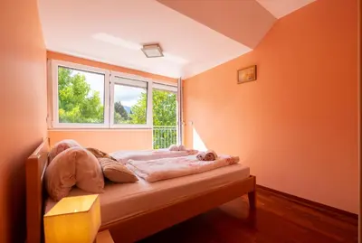 a bedroom with orange walls and a bed with a window at Apartments Apple Garden **** in Bled
