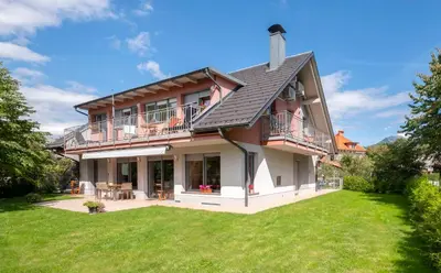 a large house with a lawn in front of it at Apartments Apple Garden **** in Bled