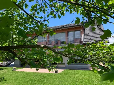 a house seen through the branches of a tree at Apartments Apple Garden **** in Bled