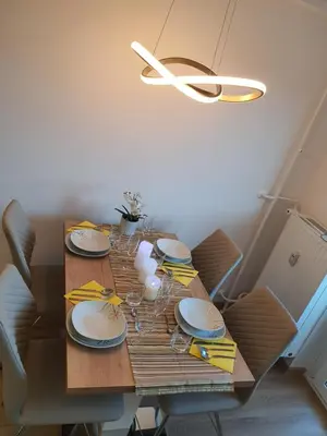 a dining room table with plates and glasses and a chandelier at Ljubljana sky view in Ljubljana