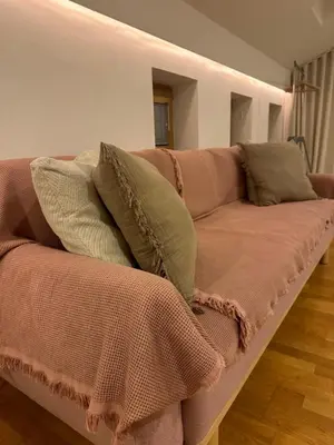 a couch with pillows on it in a living room at Zenja Apartments - Free Private Parking - Škocjan caves - Cozy garden in Divača