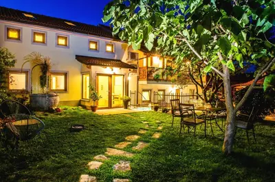 a backyard of a house with a table and chairs at Zenja Apartments - Free Private Parking - Škocjan caves - Cozy garden in Divača