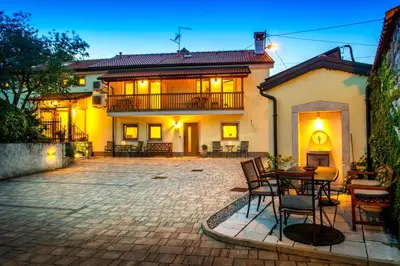 a patio with chairs and a table in front of a house at Zenja Apartments - Free Private Parking - Škocjan caves - Cozy garden in Divača