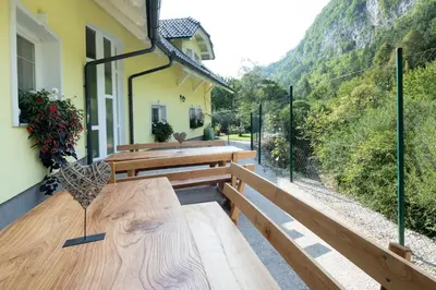 a patio with wooden benches and a view of a mountain at Apartments Grad Kamen in Begunje na Gorenjskem