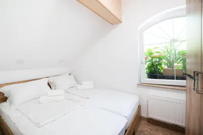 a white bed in a room with a window at Apartments Grad Kamen in Begunje na Gorenjskem