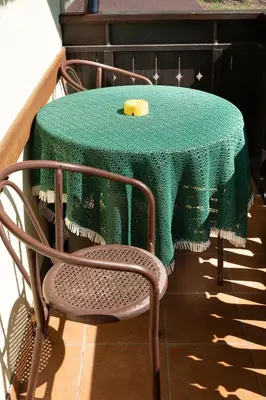 a table with a green table cloth and a chair at Penzion Rožič in Bohinj