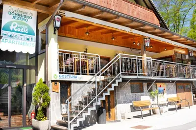 a restaurant with a staircase on the side of a building at Penzion Rožič in Bohinj