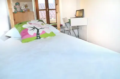 a bedroom with a white bed with a tree pillow at Blackbird House Štanjel Historic Center in Štanjel