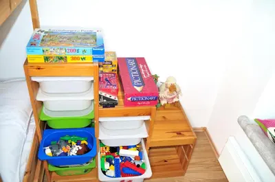 a toy shelf with bins and toys on it at Blackbird House Štanjel Historic Center in Štanjel