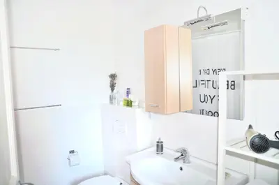 a bathroom with a sink and a toilet and a mirror at Blackbird House Štanjel Historic Center in Štanjel