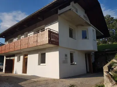 a house with a balcony on top of it at Apartma Dominik in Zgornje Gorje
