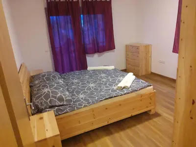 a bedroom with a bed in a room with purple curtains at Apartma Dominik in Zgornje Gorje