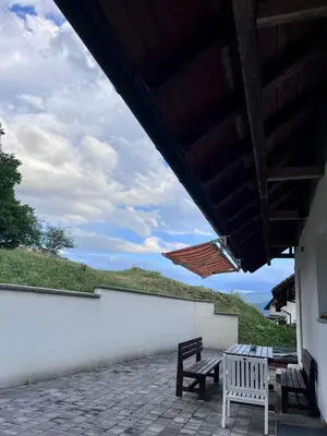 two benches sitting on a patio with a roof at Apartma Dominik in Zgornje Gorje