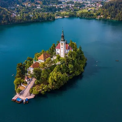 an island with a church in the middle of a lake at Apartma Dominik in Zgornje Gorje