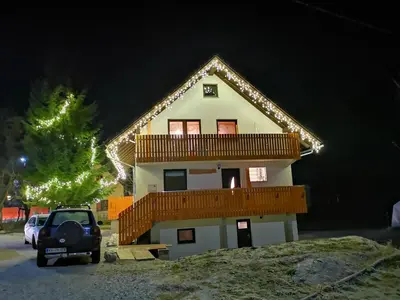 a house with a car parked in front of it at Apartmaji Gaby in Gozd Martuljek