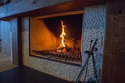 a fireplace with a fire in it with a tripod at Vinica Castle Boutique & Spa Hotel in Vinica
