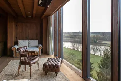 a living room with a couch and a chair and large windows at Vinica Castle Boutique & Spa Hotel in Vinica