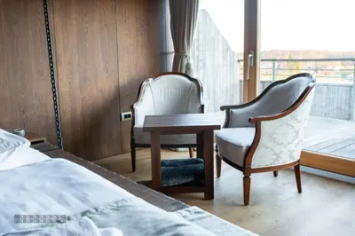 a bedroom with a desk and chairs and a bed at Vinica Castle Boutique & Spa Hotel in Vinica