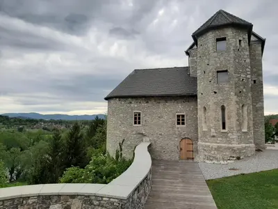 an old stone building with a wooden walkway in front at Vinica Castle Boutique & Spa Hotel in Vinica
